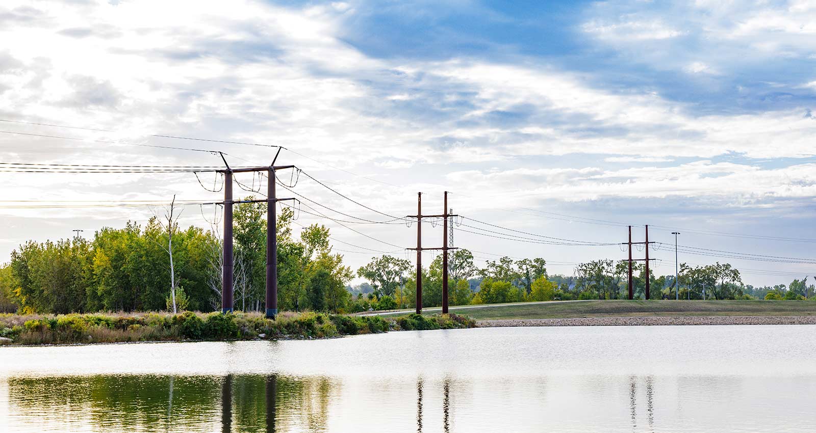 Wide shot of powerlines over water with reflections